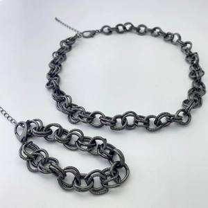 Gros plan sur l'ensemble collier et bracelet à maillons épais gris métal avec fermoir