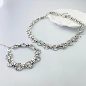 Gros plan d'un ensemble collier et bracelet argenté à maillons texturés et fermoir mousqueton