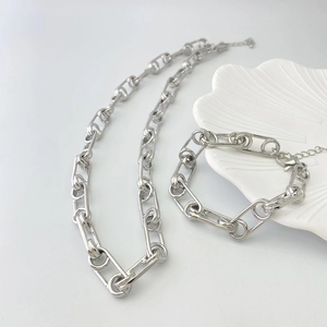 Vue détaillée d'un ensemble collier et bracelet à grosse maille argentée brillante