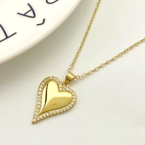 Macro shot of gold heart pendant with sparkling pavé cubic zirconia on o-chain