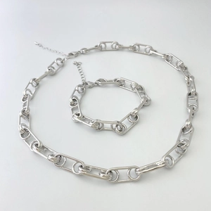 Détail de l'ensemble collier et bracelet argenté avec maillons ovales et fermoir mousqueton