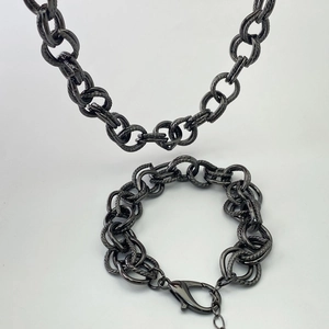 Détail de parure collier et bracelet noir avec maillons de chaîne épaisse et ciselée