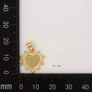 Macro detail of gold heart pendant with beaded edge on scale weighing 1.40g