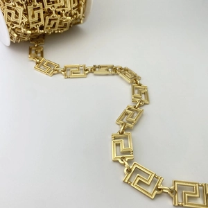 Makro-Detail einer goldenen Metallkette mit poliertem griechischem Mäander-Muster