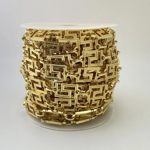 Nahaufnahme der goldenen Metallkette mit griechischem Schlüsselmuster auf einer Spule