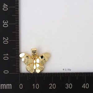 Detail of 18K gold butterfly pendant featuring a unique hammered metal texture finish
