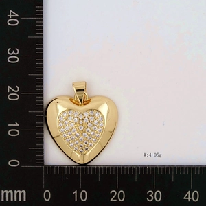 Macro shot of gold heart pendant with cubic zirconia and scale measurement