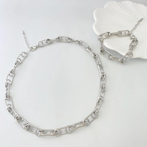 Détail de l'ensemble collier et bracelet à grosse chaîne argentée avec fermoir mousqueton