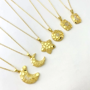 Macro detail of six 18K gold plated necklaces featuring moon and star pendants with zircons
