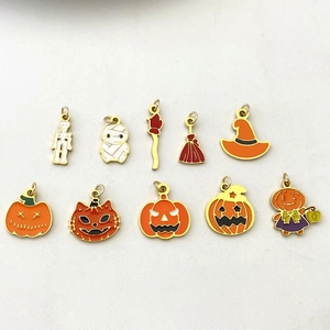 Macro detail of 10 Halloween enamel charms featuring pumpkin and ghost designs for DIY jewelry