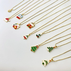 Close-up of assorted gold Christmas necklaces featuring enamel tree, snowman and snowflake pendants