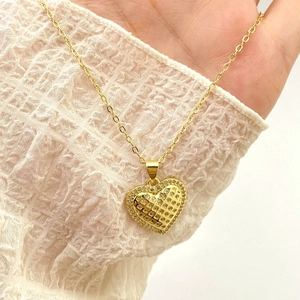 Golden heart pendant necklace with hollow mesh design and sparkling zircon inlays