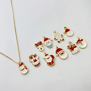 Detailed flat lay of Christmas charms including Santa and snowman on gold chains