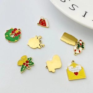 Macro shot of assorted Christmas enamel charms including bells, elk, and trees for DIY jewelry