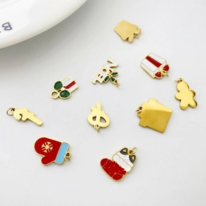 Flat lay of festive Christmas charms including snowman and gift box for DIY jewelry