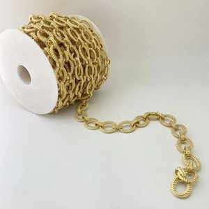 Makrodetail einer goldenen strukturierten Gliederkette für DIY-Schmuck auf einer Spule