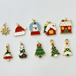 Detailed view of 10 Christmas themed enamel pendants with festive gold metal finish