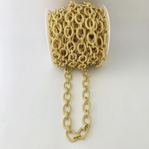 Nahaufnahme der goldenen ovalen Gliederkette für DIY Schmuck auf weißer Spule
