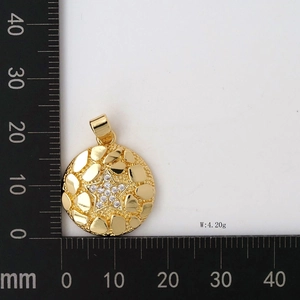 Macro detail of a 24mm gold nugget texture pendant with a CZ star inlay and 4.20g weight
