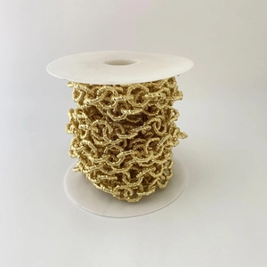 Nahaufnahme der goldenen gedrehten Gliederkette auf einer Spule für DIY-Schmuckherstellung