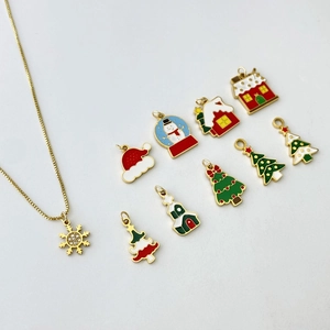 Detail of Christmas gold necklace set with snowflake pendant and enamel charms