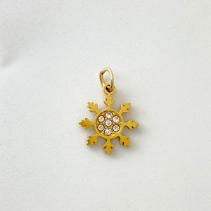Detailed close-up of a gold snowflake pendant featuring seven sparkling clear rhinestones