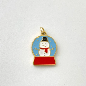 Macro detail of Christmas snowman pendant in blue globe with red enamel base
