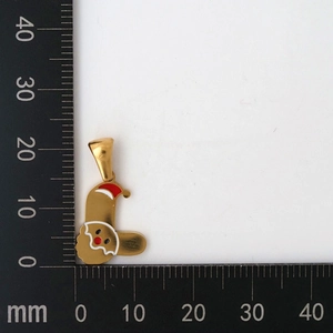 Dettaglio di un ciondolo Babbo Natale dorato da 25mm con smalto rosso su scala graduata