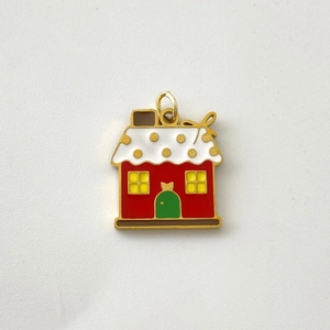 Detailed view of a small colorful enamel house pendant with red walls and a white roof