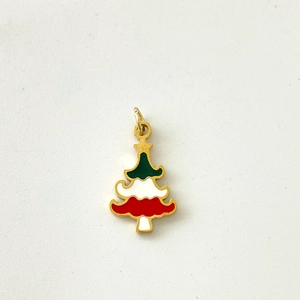 Detail view of a gold-plated Christmas tree pendant with red, white and green enamel