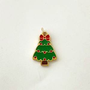 Detailed view of an enamel Christmas tree pendant with green leaves and a red bow knot
