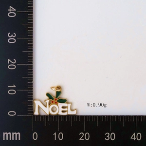 Detail view of Noel Christmas pendant showing dimensions with ruler and holly leaf accents