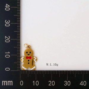 Macro detail of gingerbread man charm in gold finish with red bow and size scale
