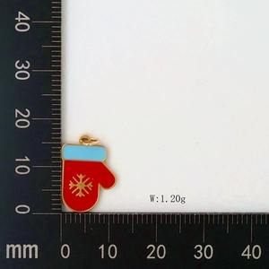 Detail showing red enamel Christmas glove pendant with snowflake pattern and scale measurements