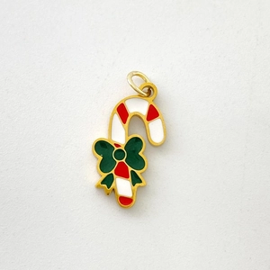 Macro view of candy cane pendant with red and white stripes and a green bow