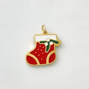 Detail view of festive red and white enamel Christmas stocking pendant with gold metal trim