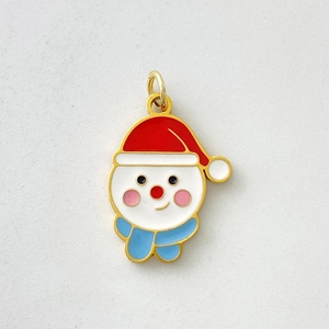 Detail of cute enamel snowman charm in gold plating with festive red hat and blue scarf