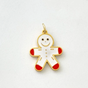 Macro view of gingerbread man charm with white enamel and golden base details