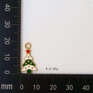 Detailed view of a green enamel Christmas tree pendant with scale showing 0.80g weight