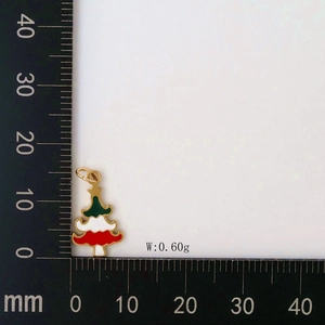 Macro detail of a colorful enamel Christmas tree pendant with golden outline on white background