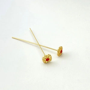 Dettaglio macro di spilli a testa di fiore placcati oro 18K con smalto rosso per gioielli
