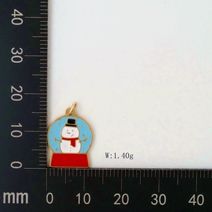 Macro shot of a golden snowman pendant with blue background and 18mm measurement scale