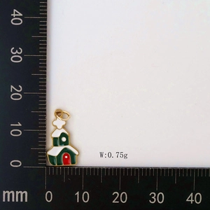 Detail view of a green church charm pendant with red door and white snow for DIY jewelry