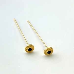 Dettaglio di perni a T placcati oro 18K con fiori in smalto nero e texture a raggiera
