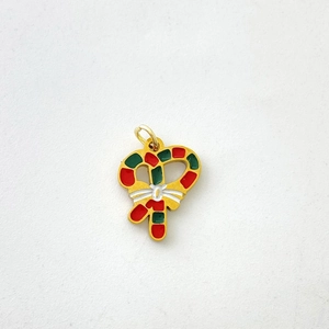 Detail of festive red and green Christmas candy cane pendant with gold metal ring hook