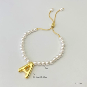 Detail showing 6mm pearl bracelet with golden letter A pendant and adjustable chain