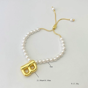 Detail of beaded pearl bracelet with gold letter B pendant and adjustable chain