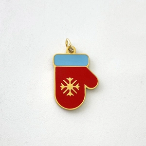 Close-up of red and blue enamel glove pendant with golden snowflake detail for Christmas