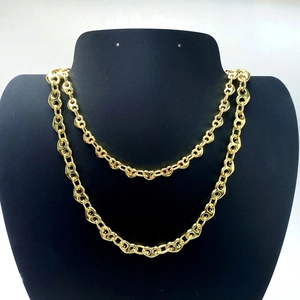 Detail view of double-layer golden pig nose chain necklace on black velvet display