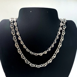 Close-up of polished silver double-layer pig nose link chain necklace on display stand